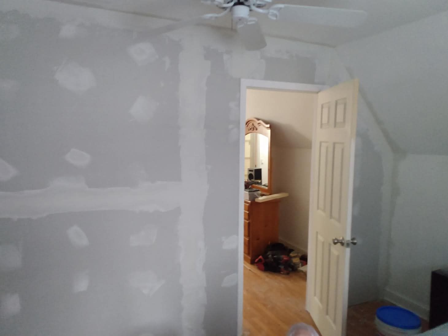 A room with a ceiling fan and a door that is open