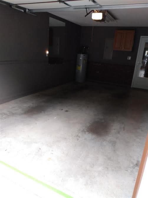 An empty garage with a water heater in it.