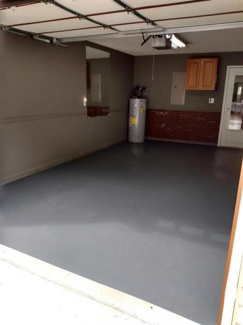 An empty garage with a water heater and cabinets
