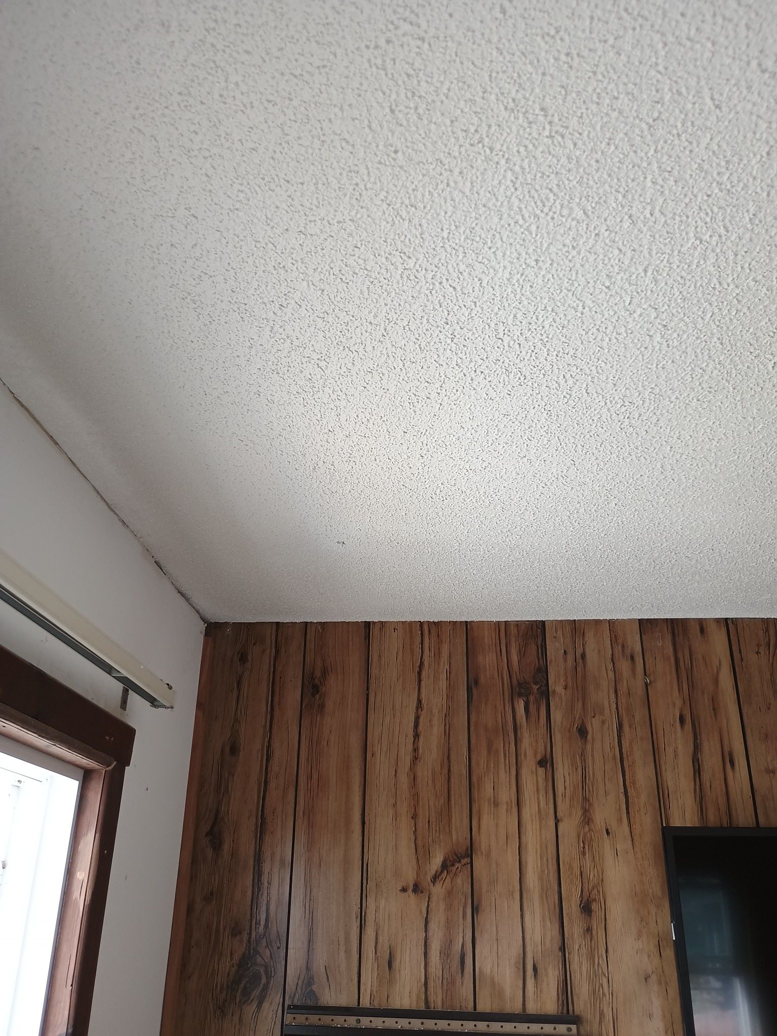 A room with a wooden wall and a white ceiling.