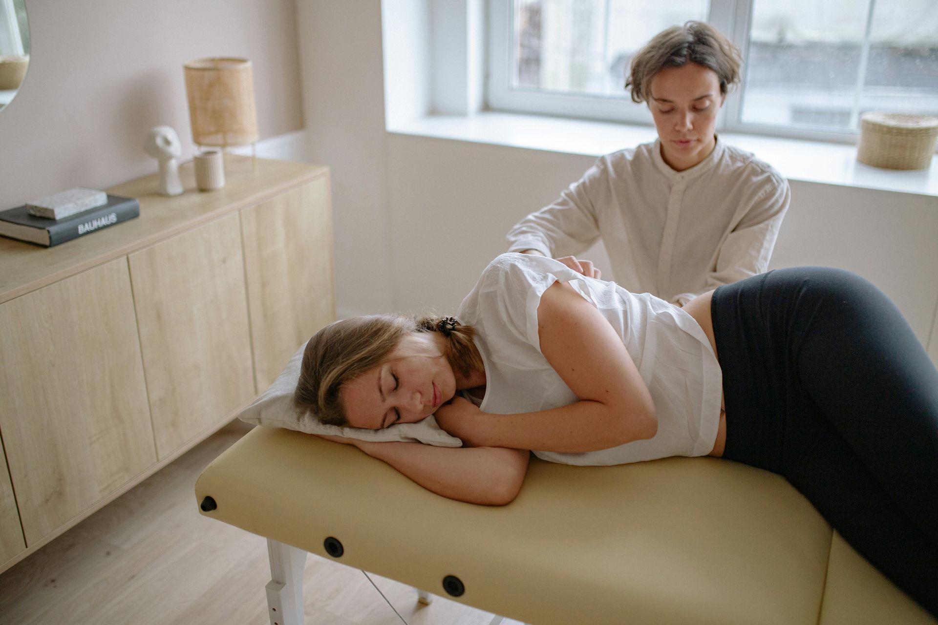 Photo of a chiropractor giving a comprehensive massage to a woman with back pain