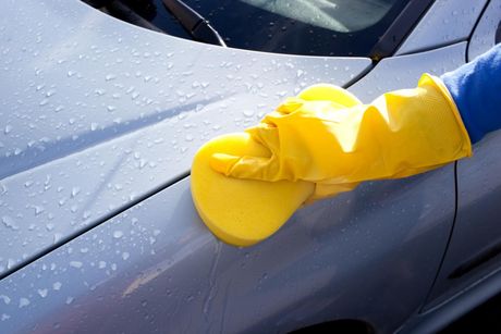 someone using the sponge to clean the car