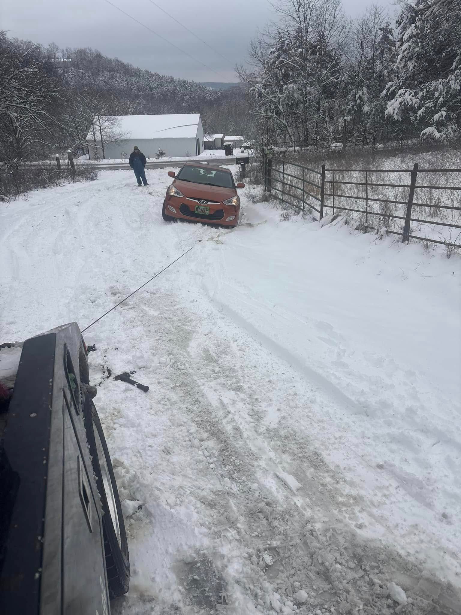 A car is stuck in the snow on a snowy road.