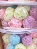 A plastic container filled with colorful cotton candy balls.