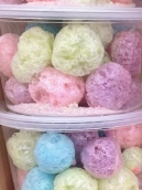A plastic container filled with colorful cotton candy balls.