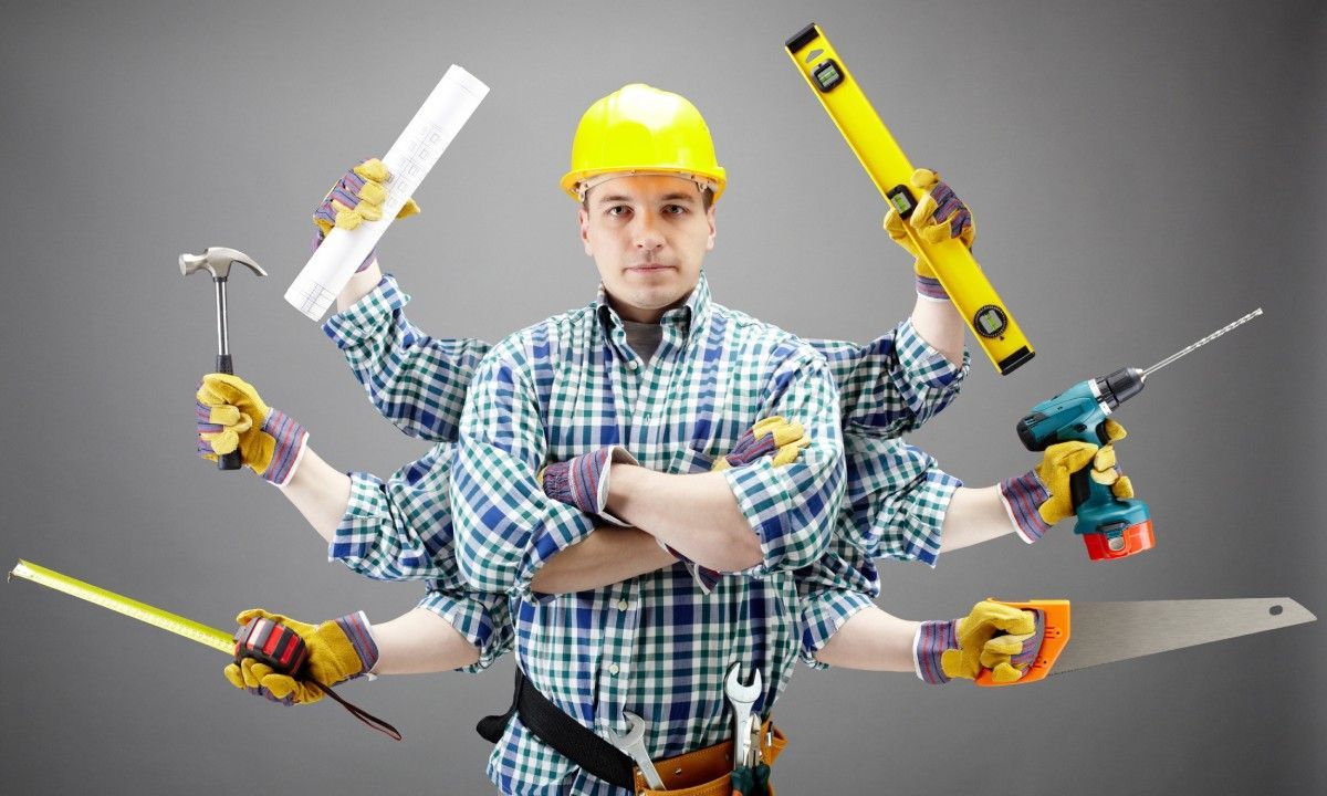 A handyman in a hard hat, flannel, and tool belt stands with arms crossed while six arms hold various tools behind him.