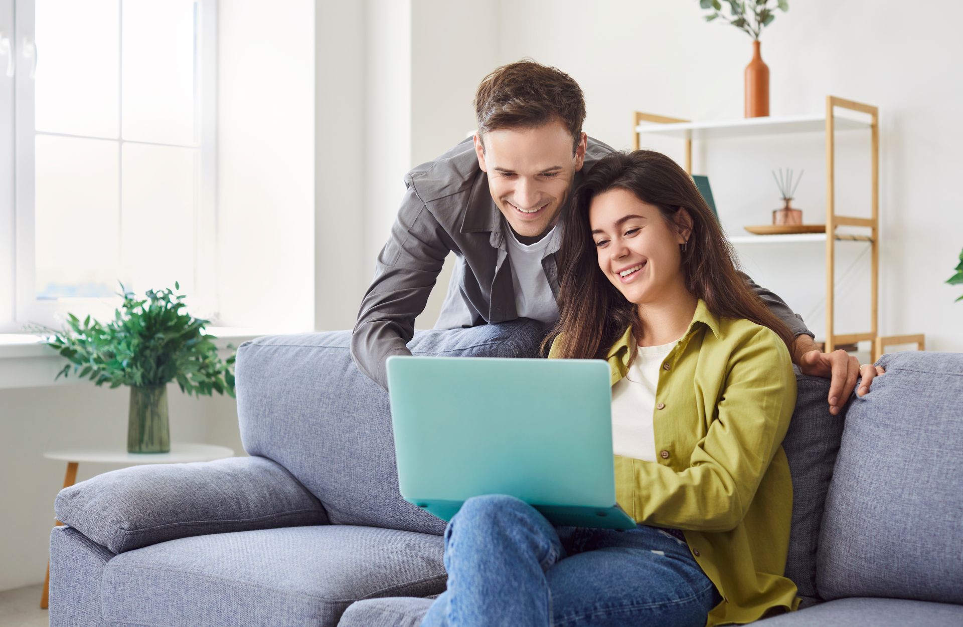 A person is holding a smart phone in their hand in a living room.