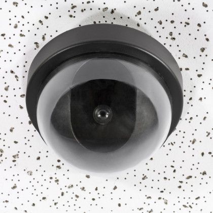 A security camera is sitting on a white ceiling
