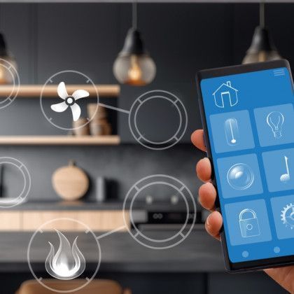 A person is holding a smart phone in front of a kitchen.