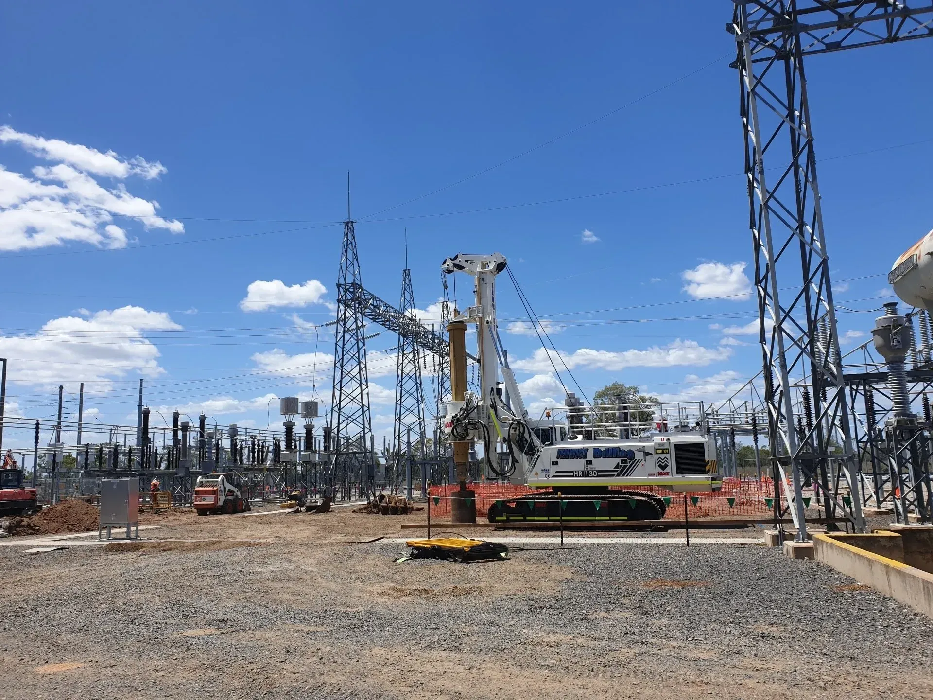 A large crane is working on a power line in a power station.