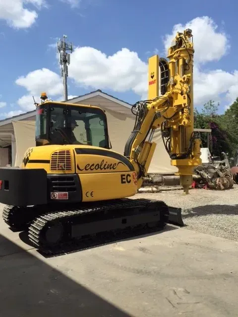 A yellow ecoline excavator is parked in a parking lot