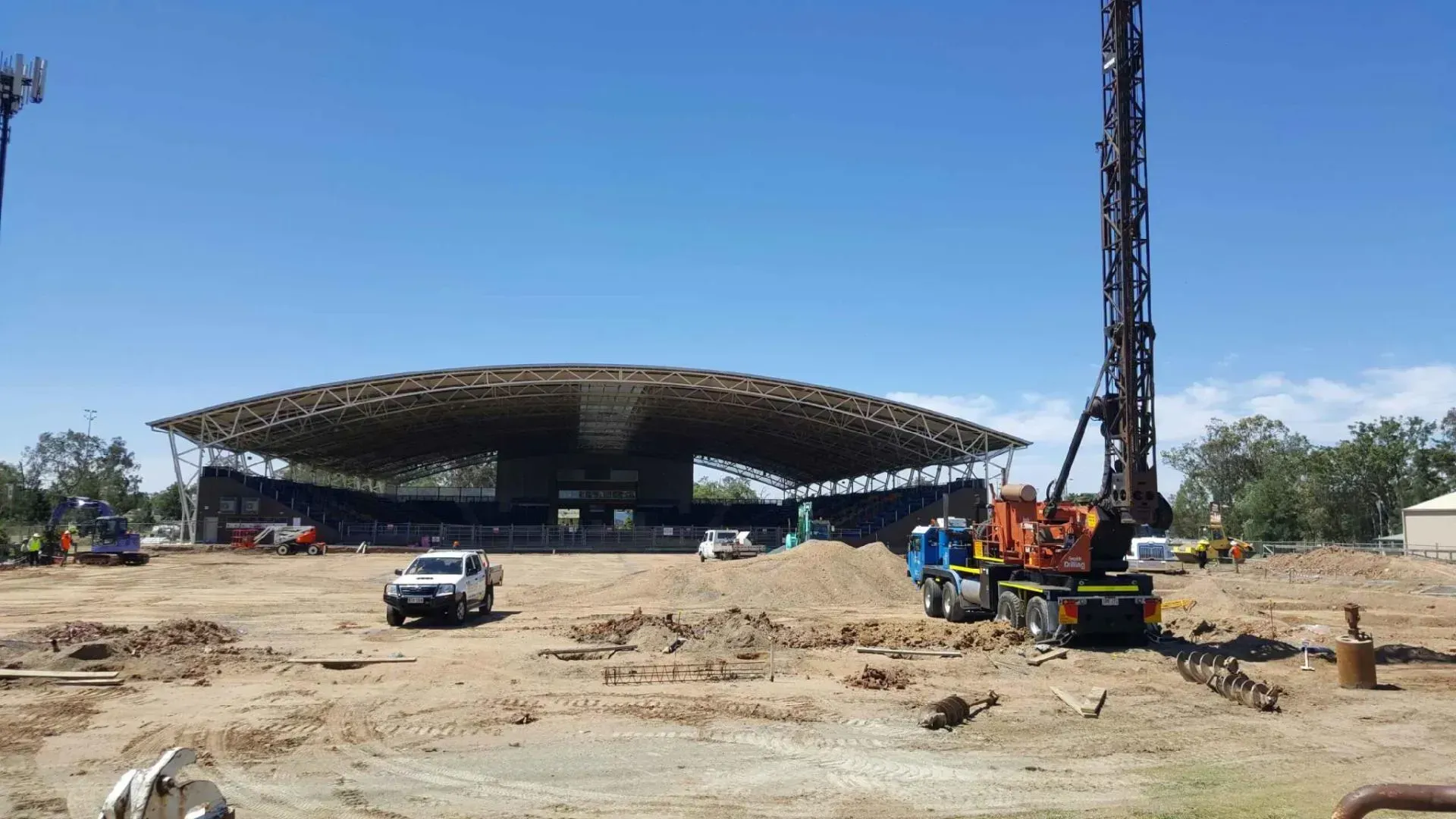 A construction site with a large building in the background.