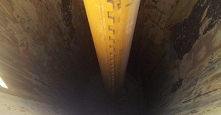 A yellow pipe is going through a tunnel.