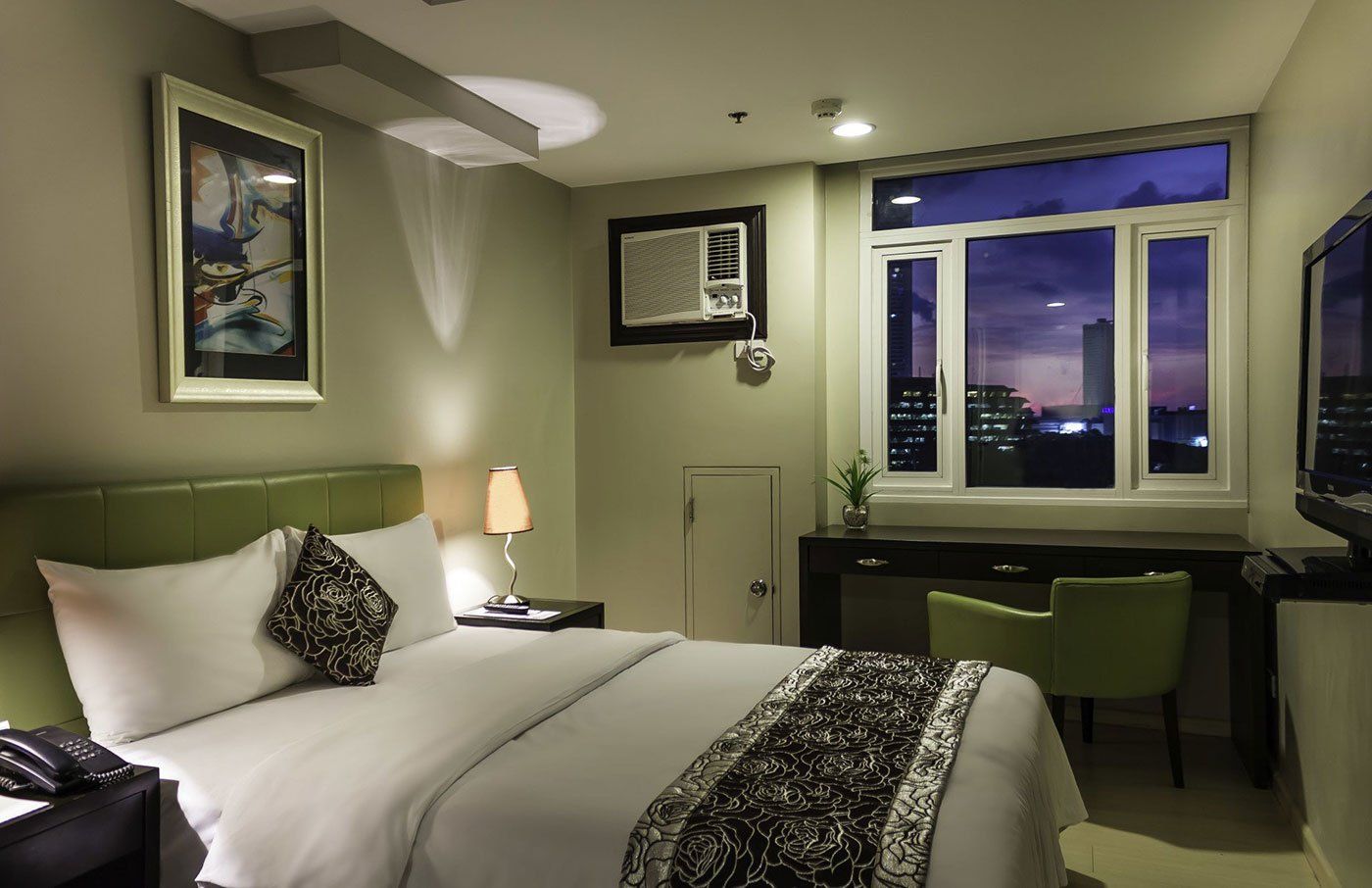 A pizza and a plate of fruit are on a table next to a menu from The Exchange Regency Hotel in Ortigas