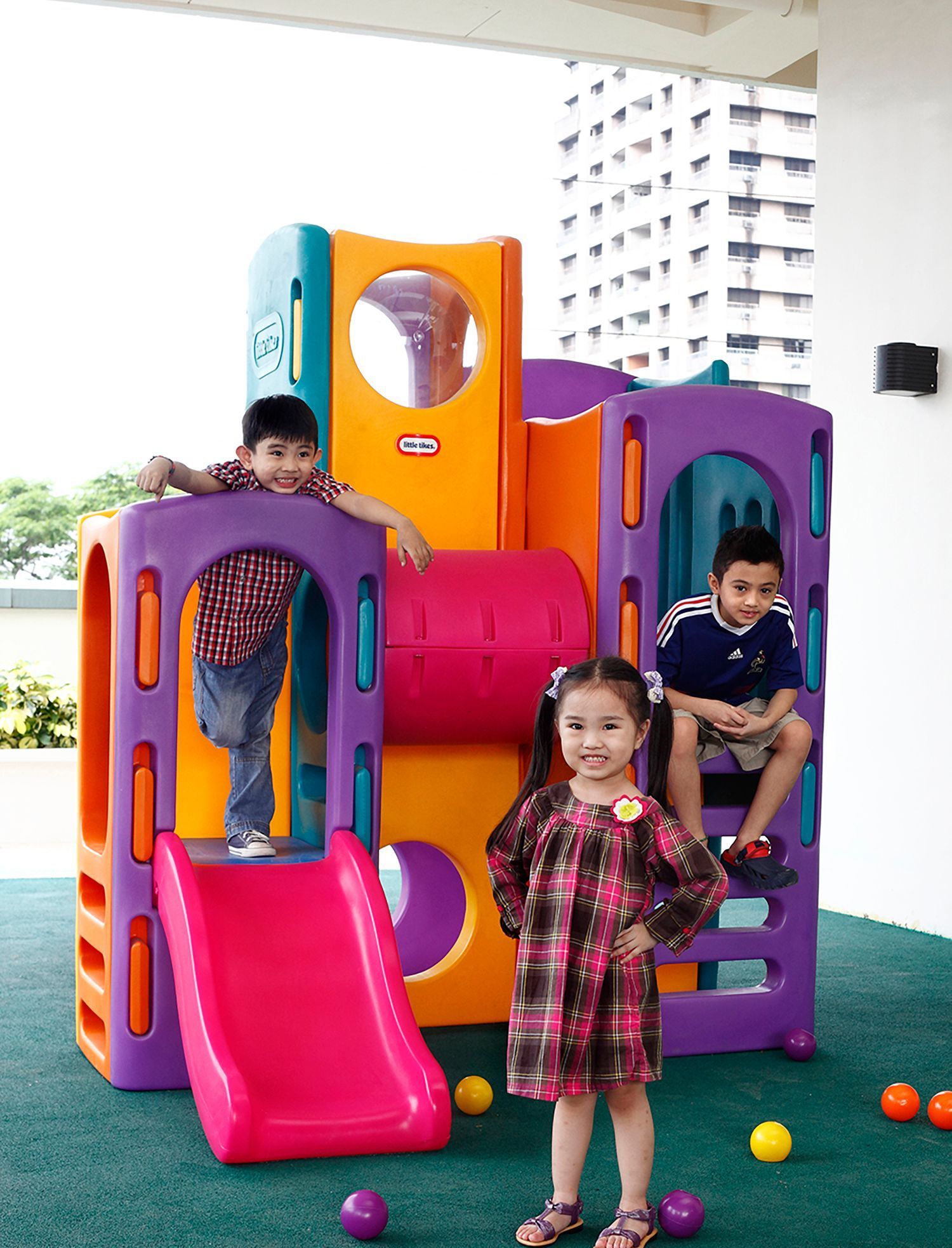 A little tikes playground with a girl standing in front of it and two boys at the play area of The Exchange Regency Hotel