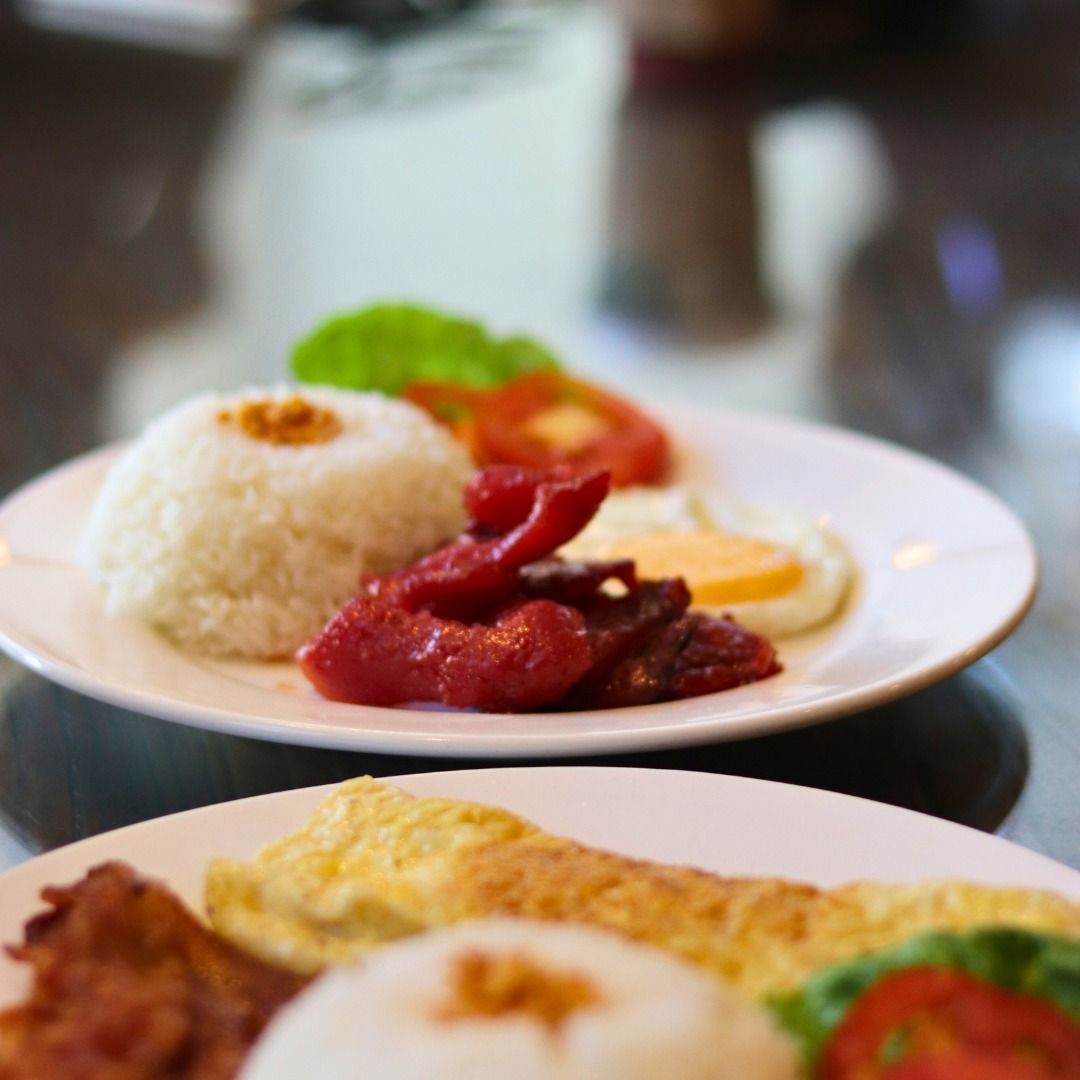 Two plates of Filipino breakfast food on a table at Tully's Cafe.