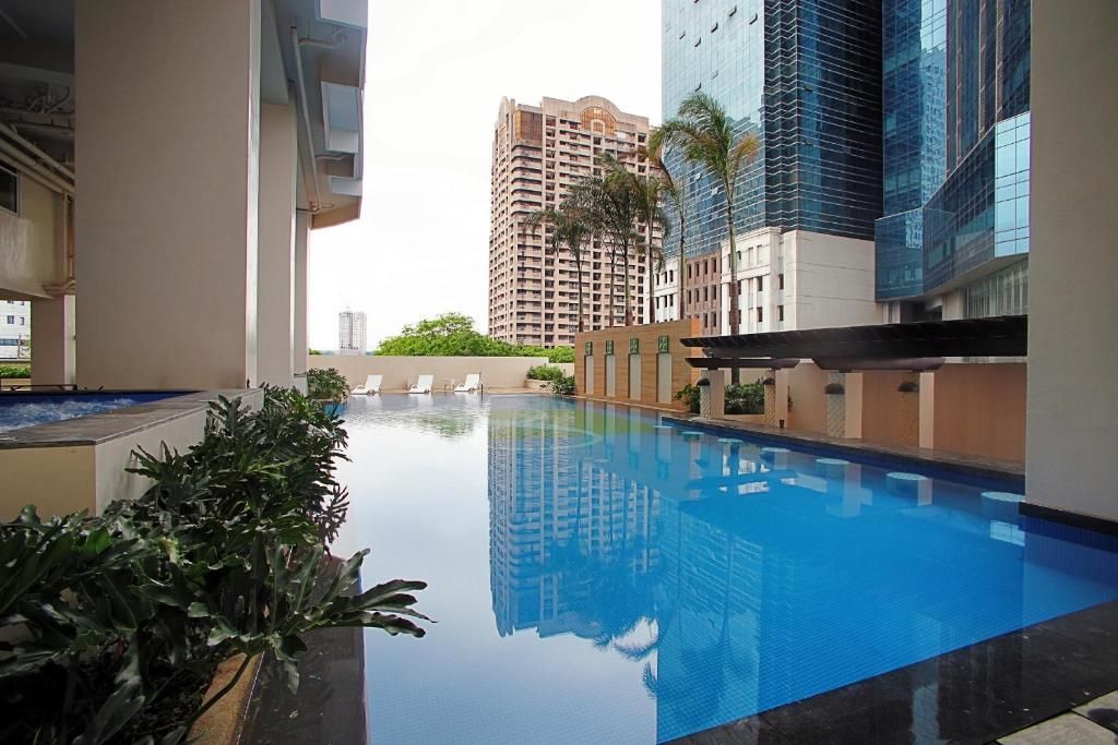 A large swimming pool is surrounded by tall buildings
