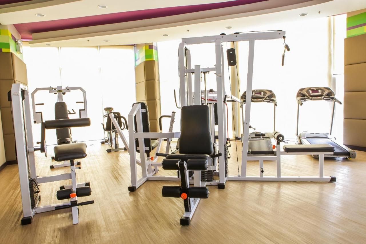 Gym with various exercise machines: weight machines, treadmills, and stationary bikes at a hotel near Robinsons Galleria