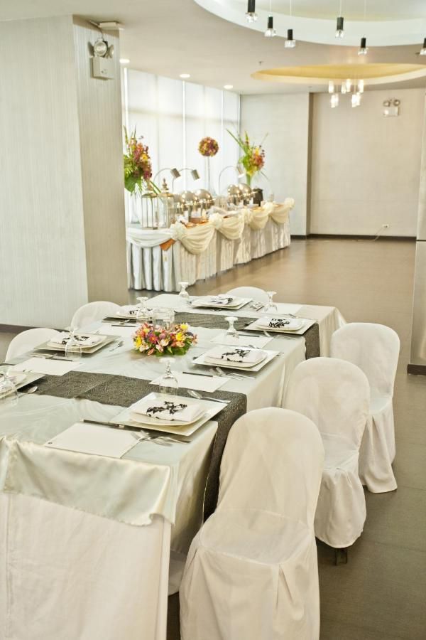 A room with tables and chairs set up for a wedding reception