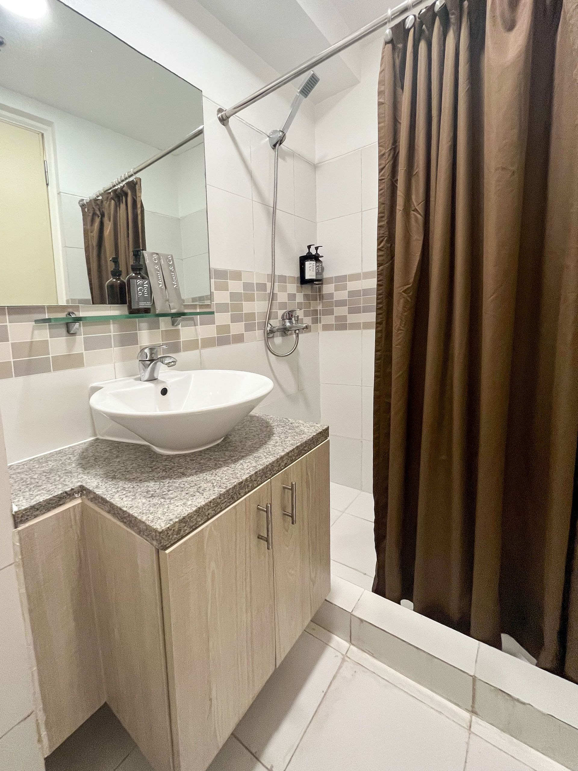 A bathroom with a sink , mirror and shower curtain.