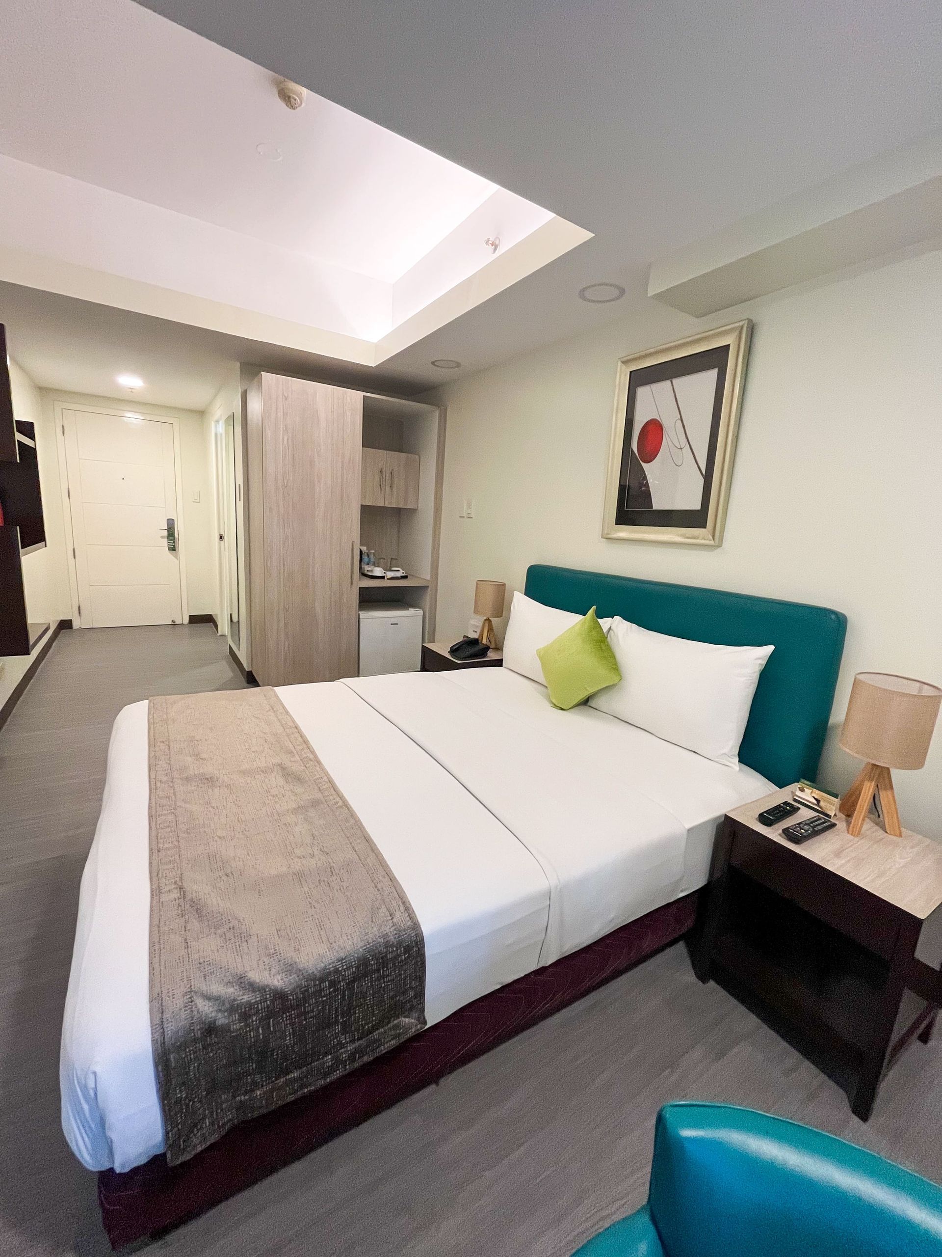 A hotel room with a large bed and a chair