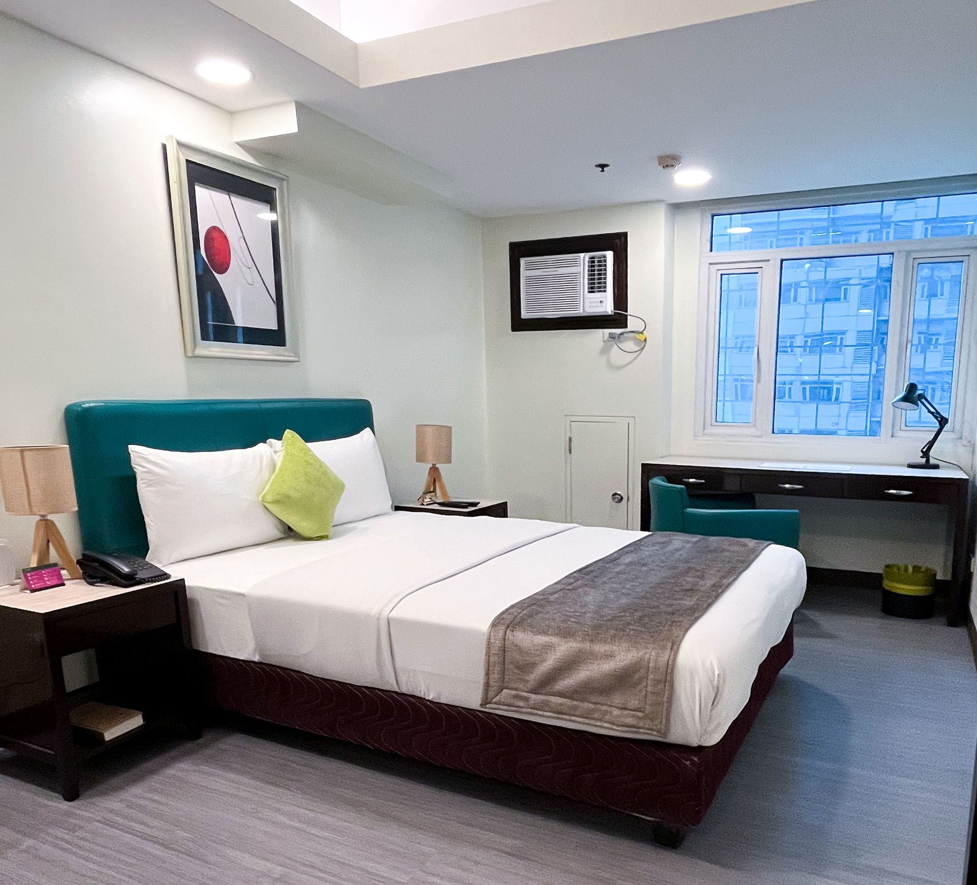 A hotel room with a king size bed and a desk