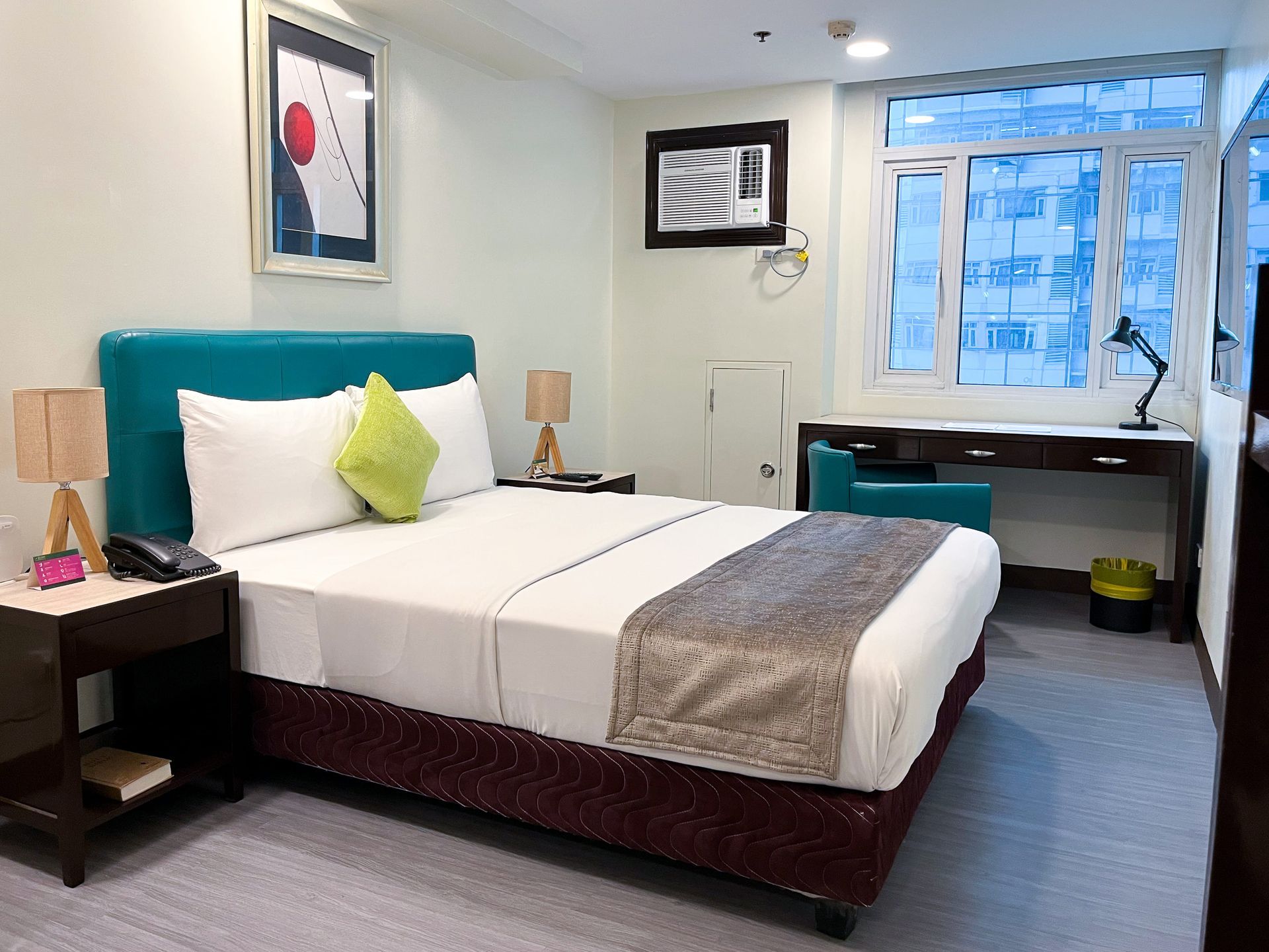 A hotel room with a king size bed and a desk