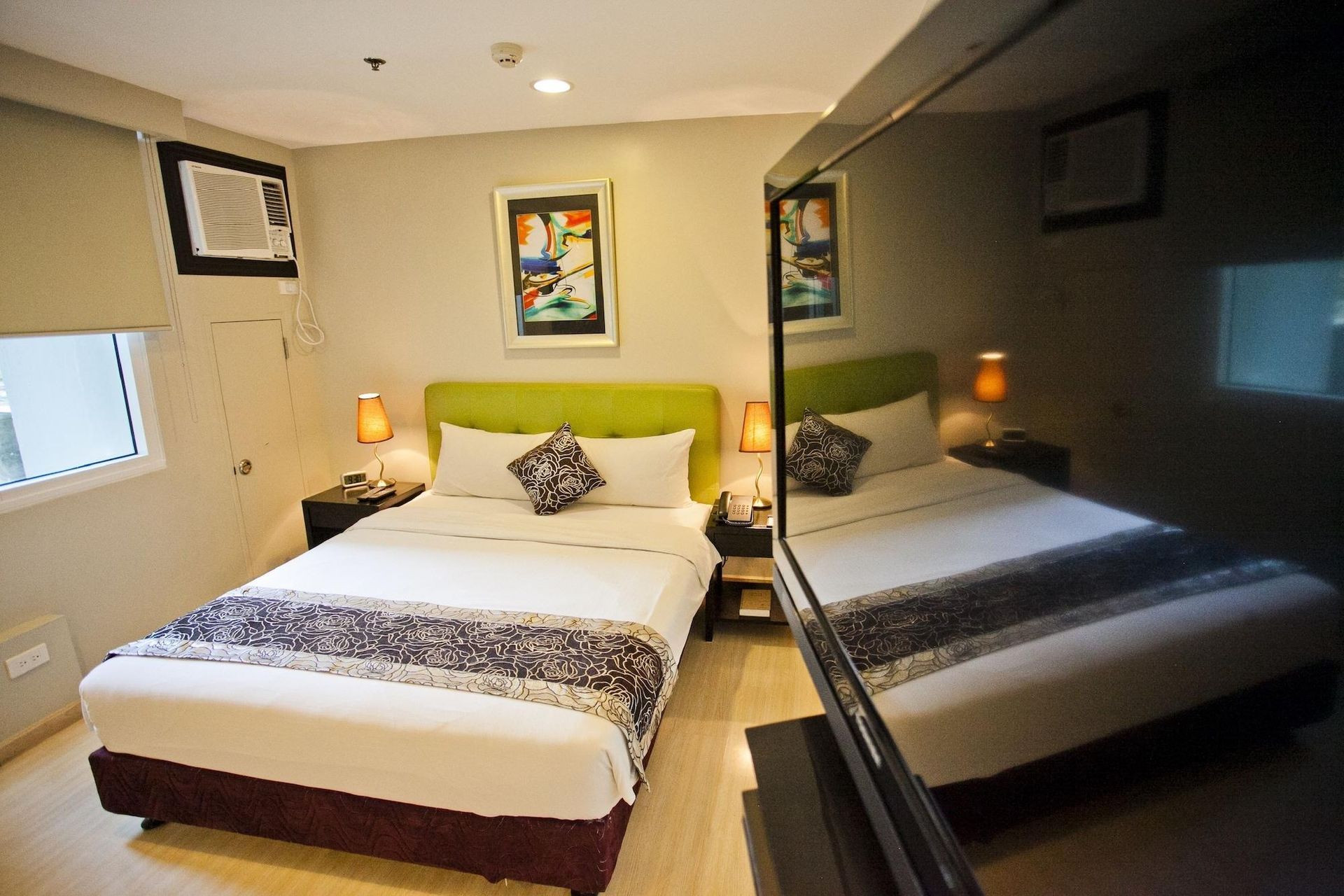 A hotel room with a large bed and a flat screen tv