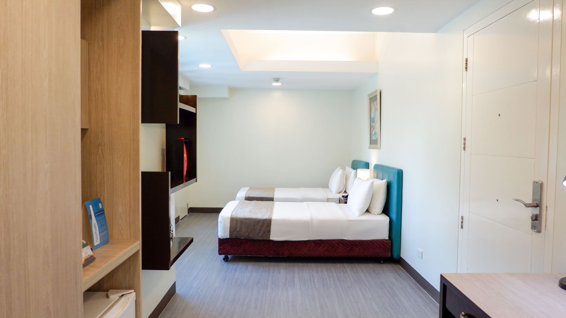 A hotel room with two beds and a television.