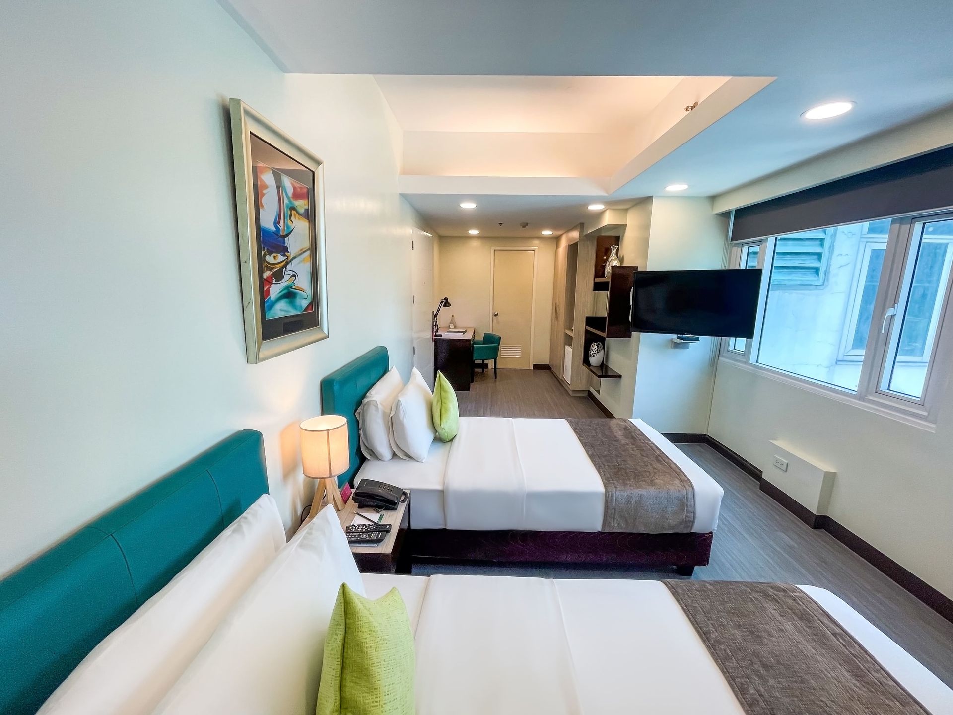 A hotel room with two beds and a flat screen tv.