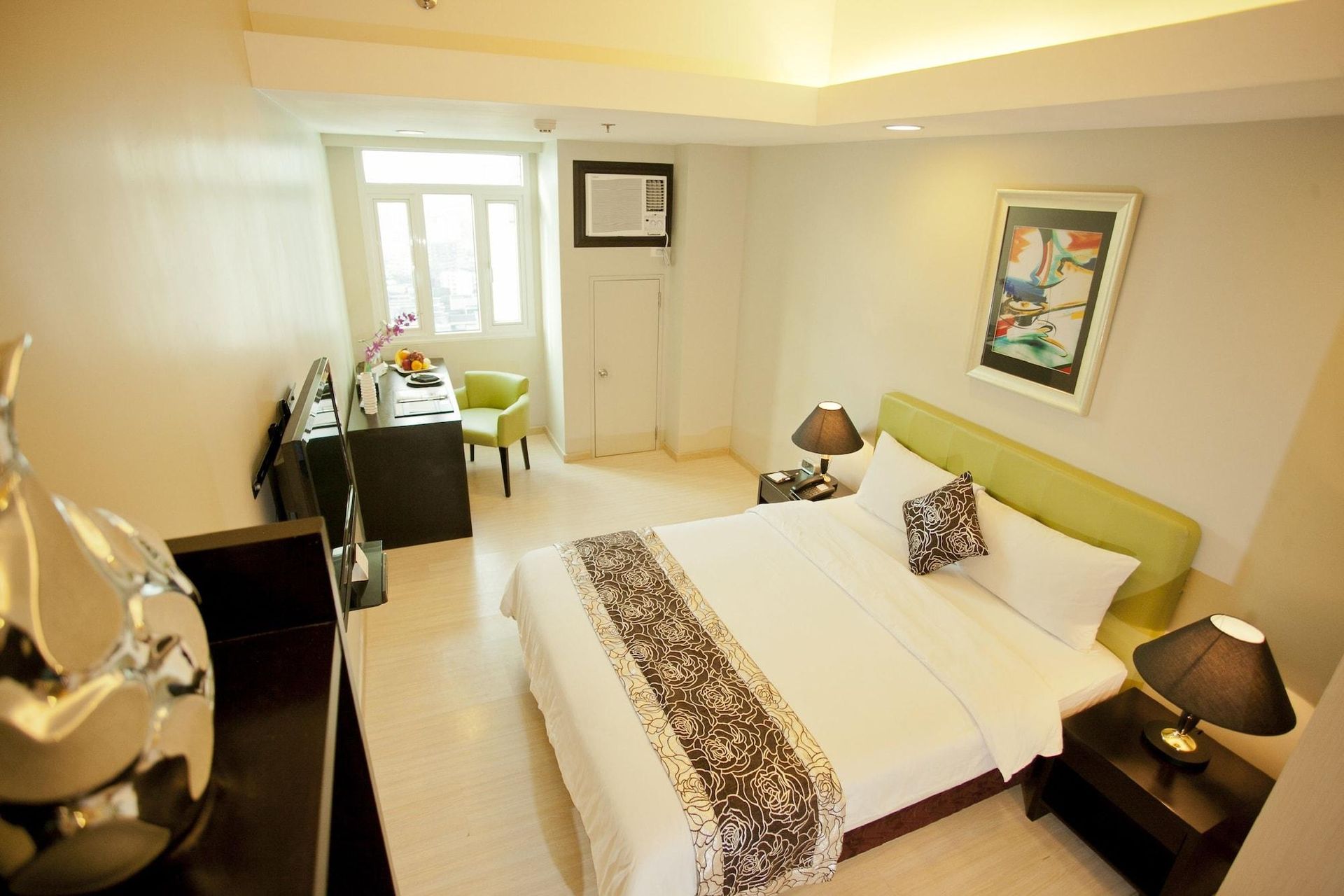 A hotel room with a large bed and two lamps