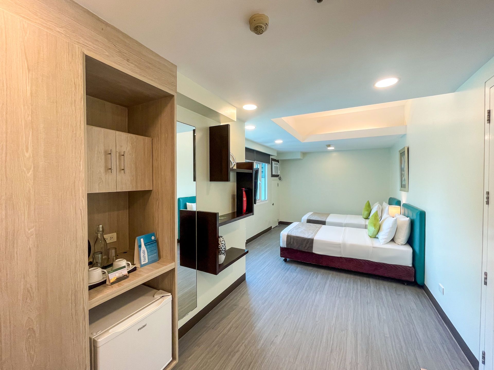 A hotel room with two beds and a refrigerator.