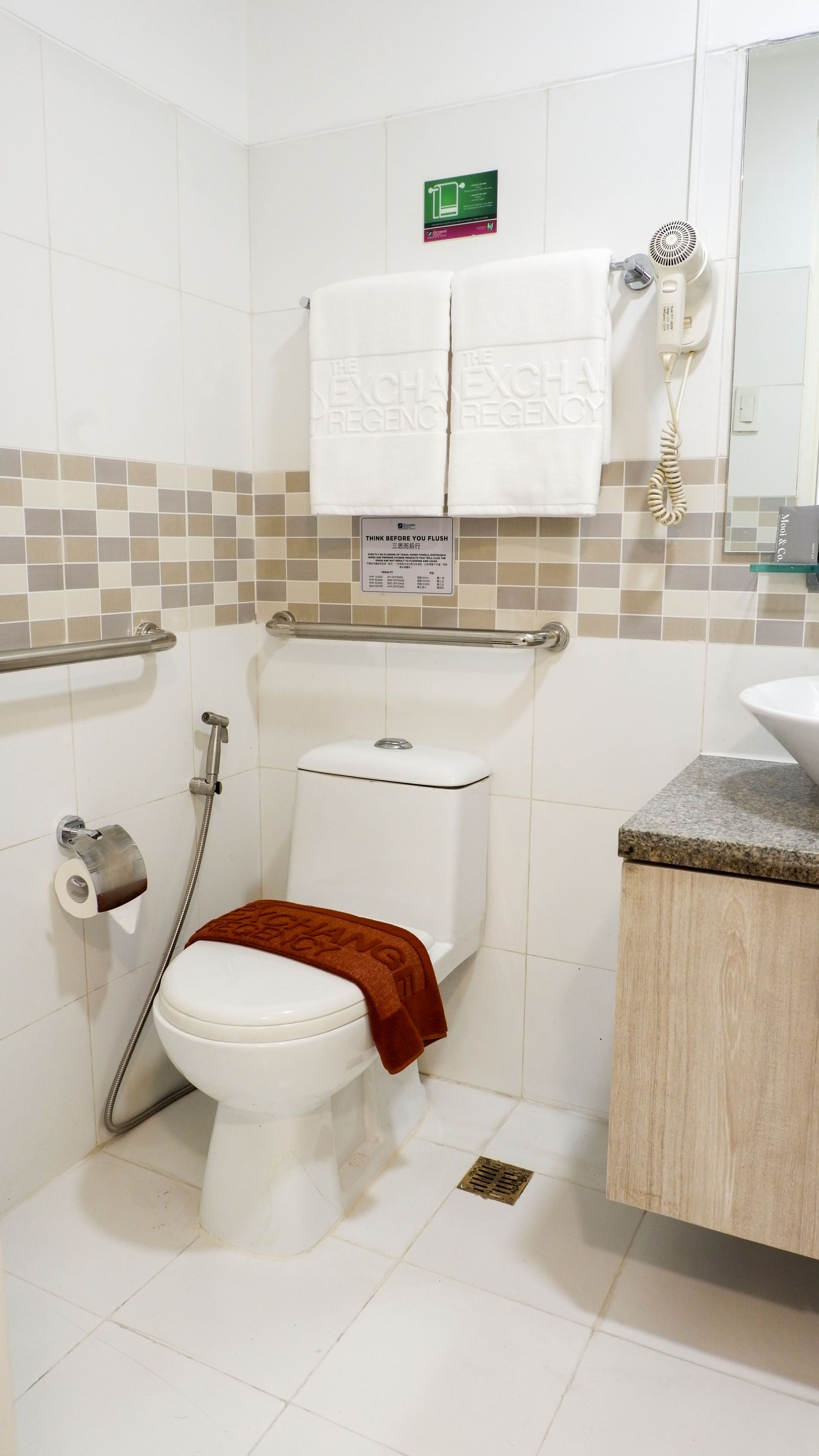 A bathroom with a toilet , sink and mirror.