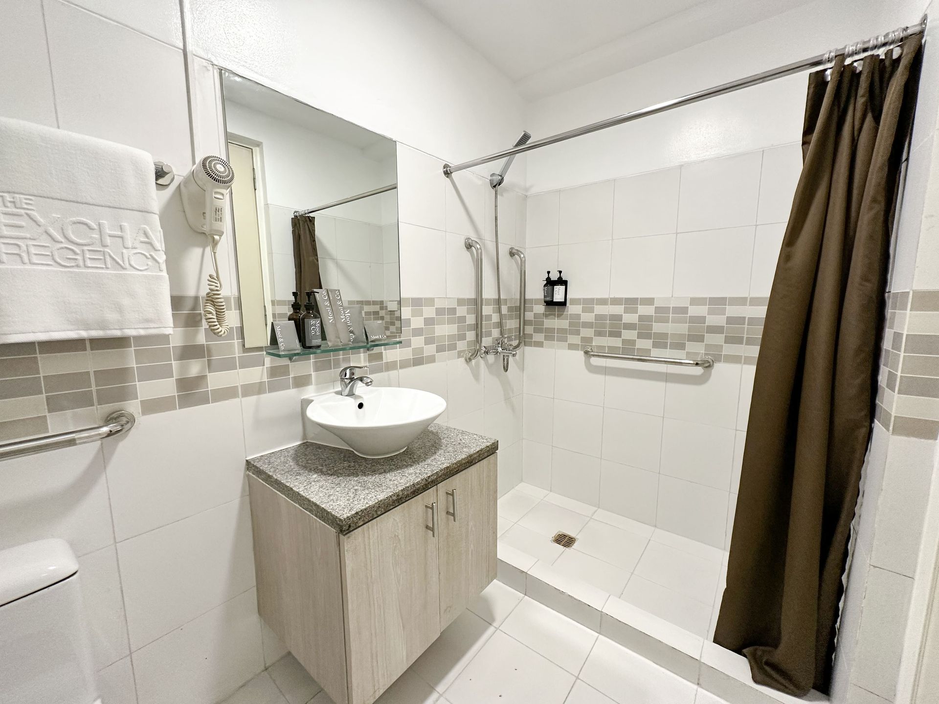 A bathroom with a sink and a walk in shower.