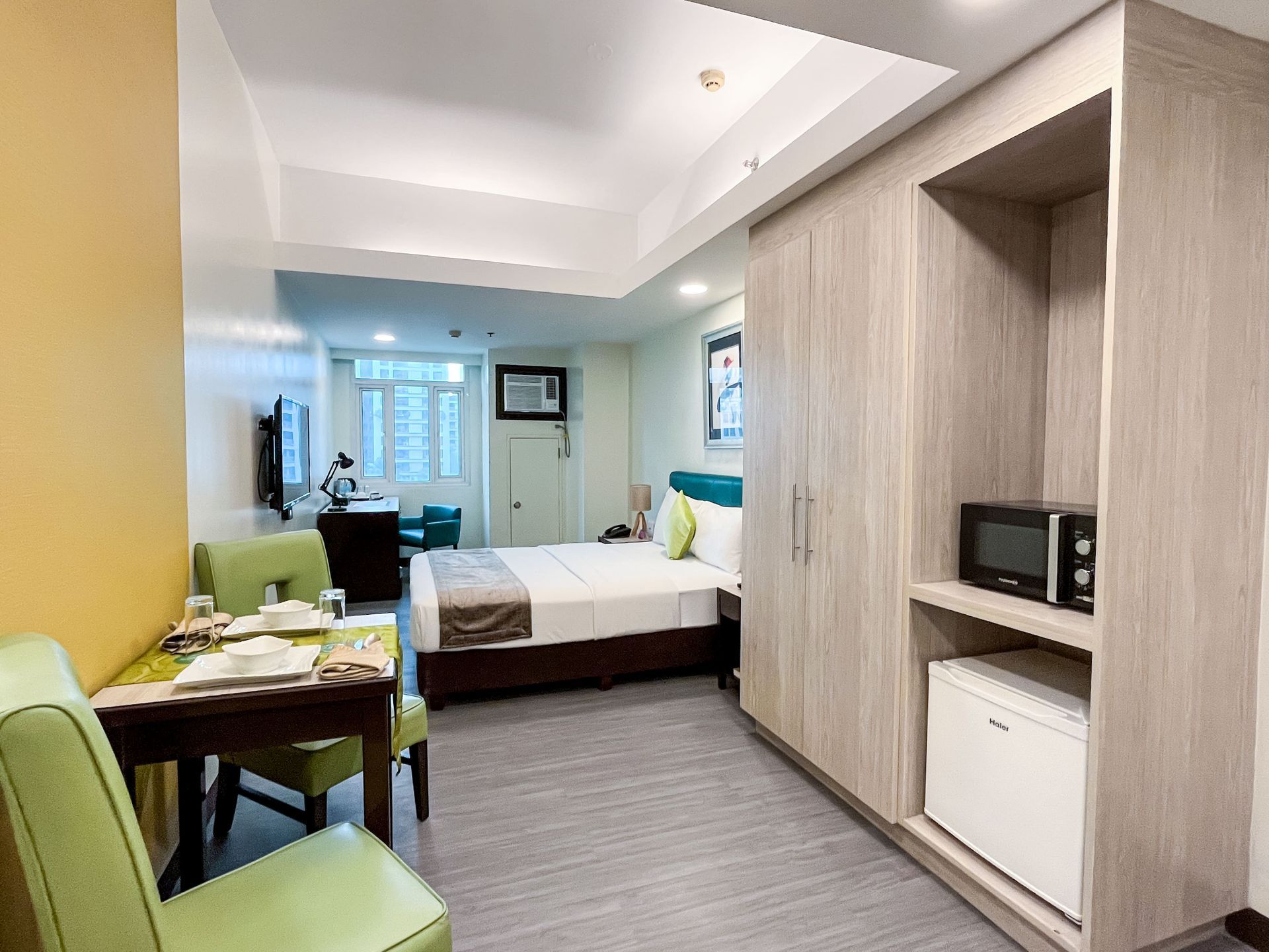 A hotel room with a bed , table and chairs.