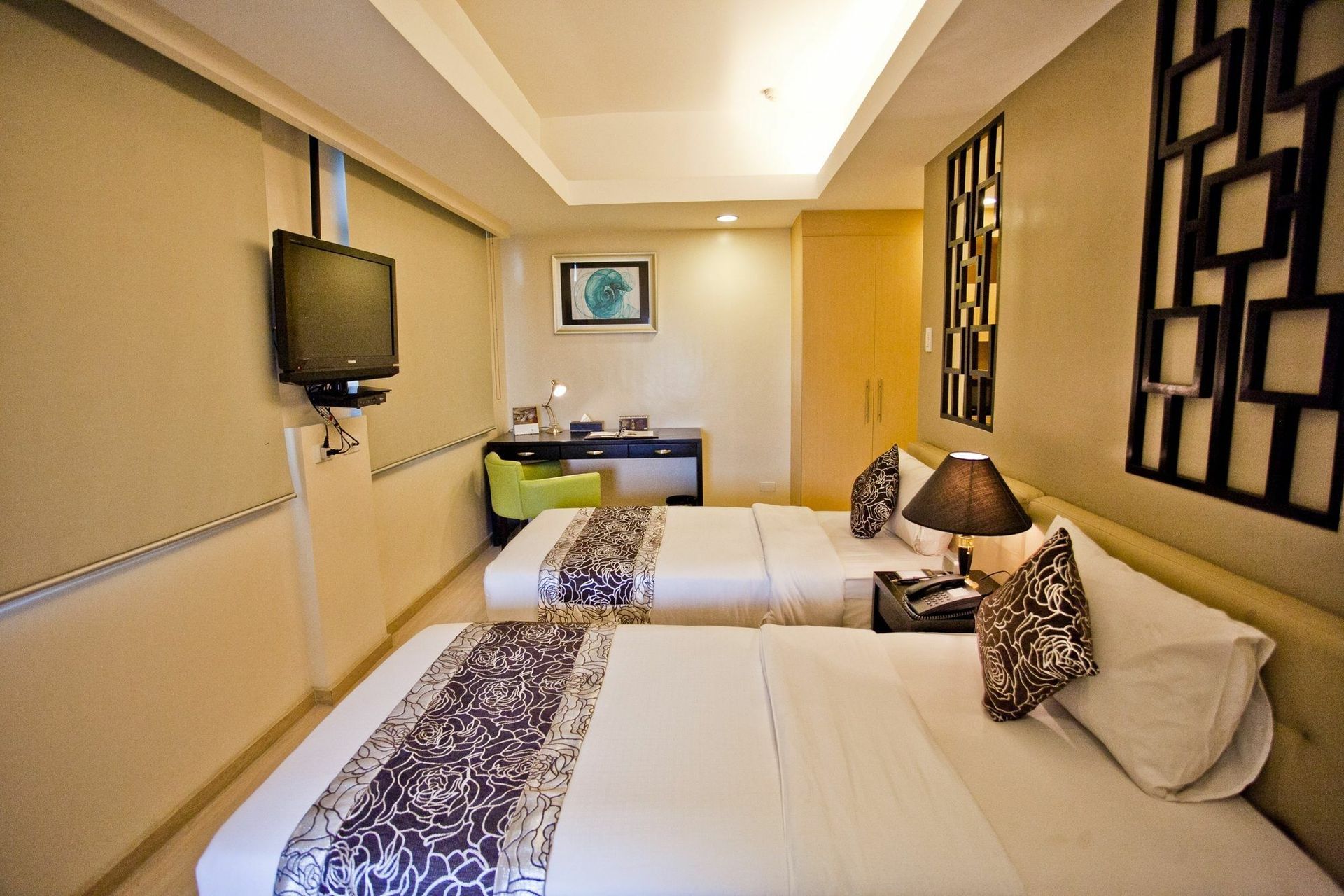 A hotel room with two beds and a flat screen tv