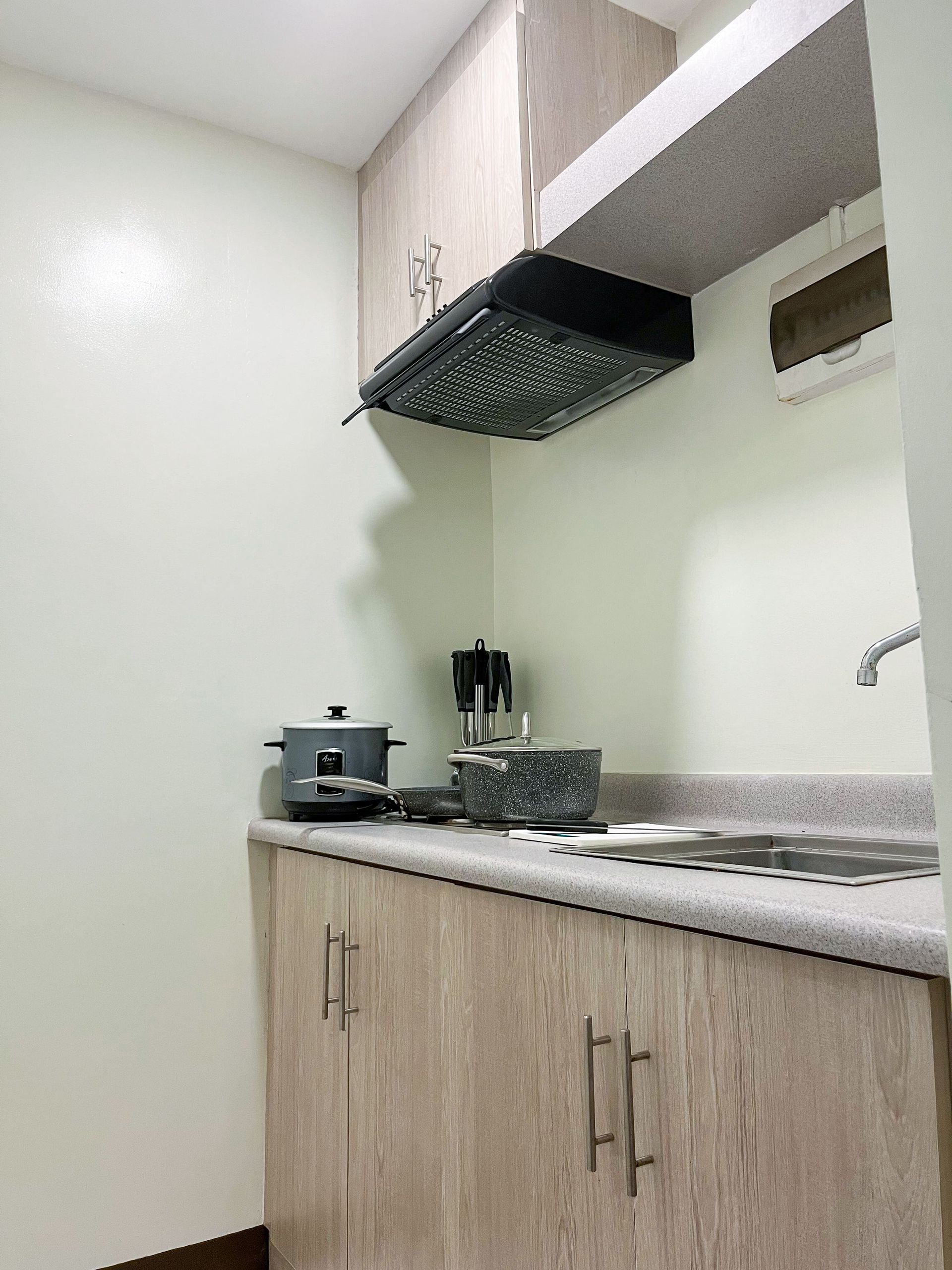 A small kitchen with wooden cabinets and a stove top oven.