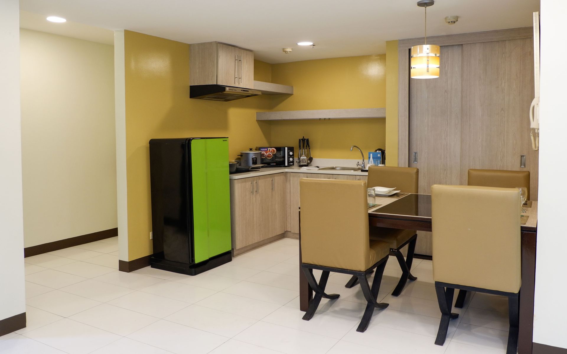 A kitchen with a green refrigerator and a dining table and chairs.