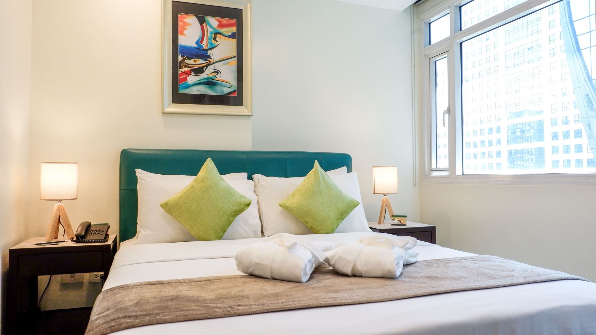 A hotel room with a king size bed and a window.