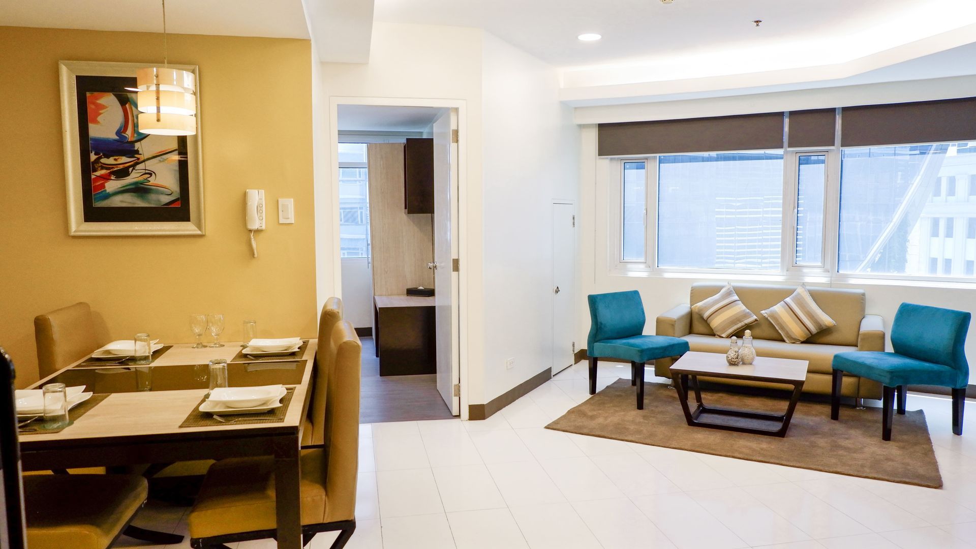 A living room with a couch , table and chairs.