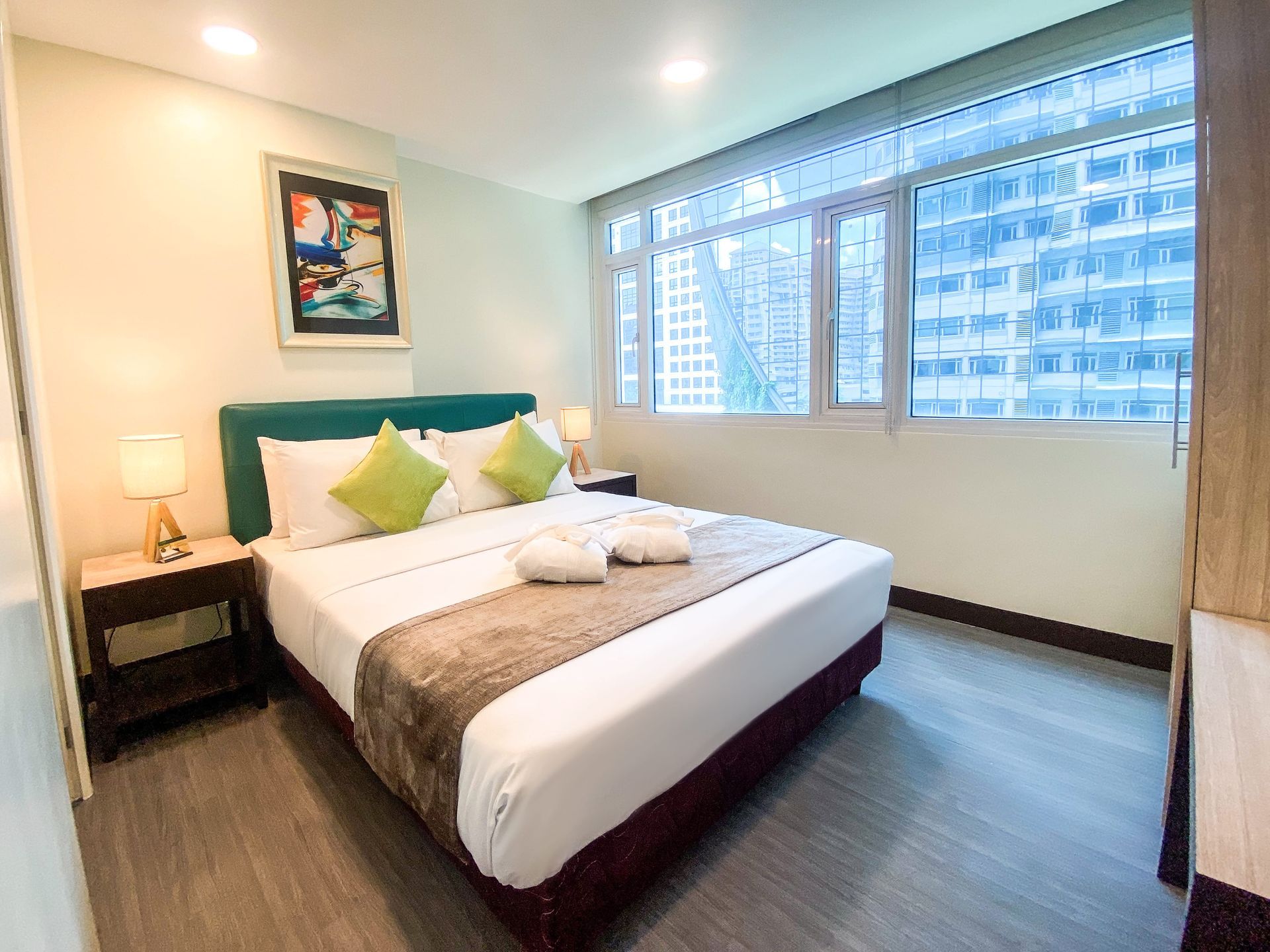 A hotel room with a king size bed and a large window.