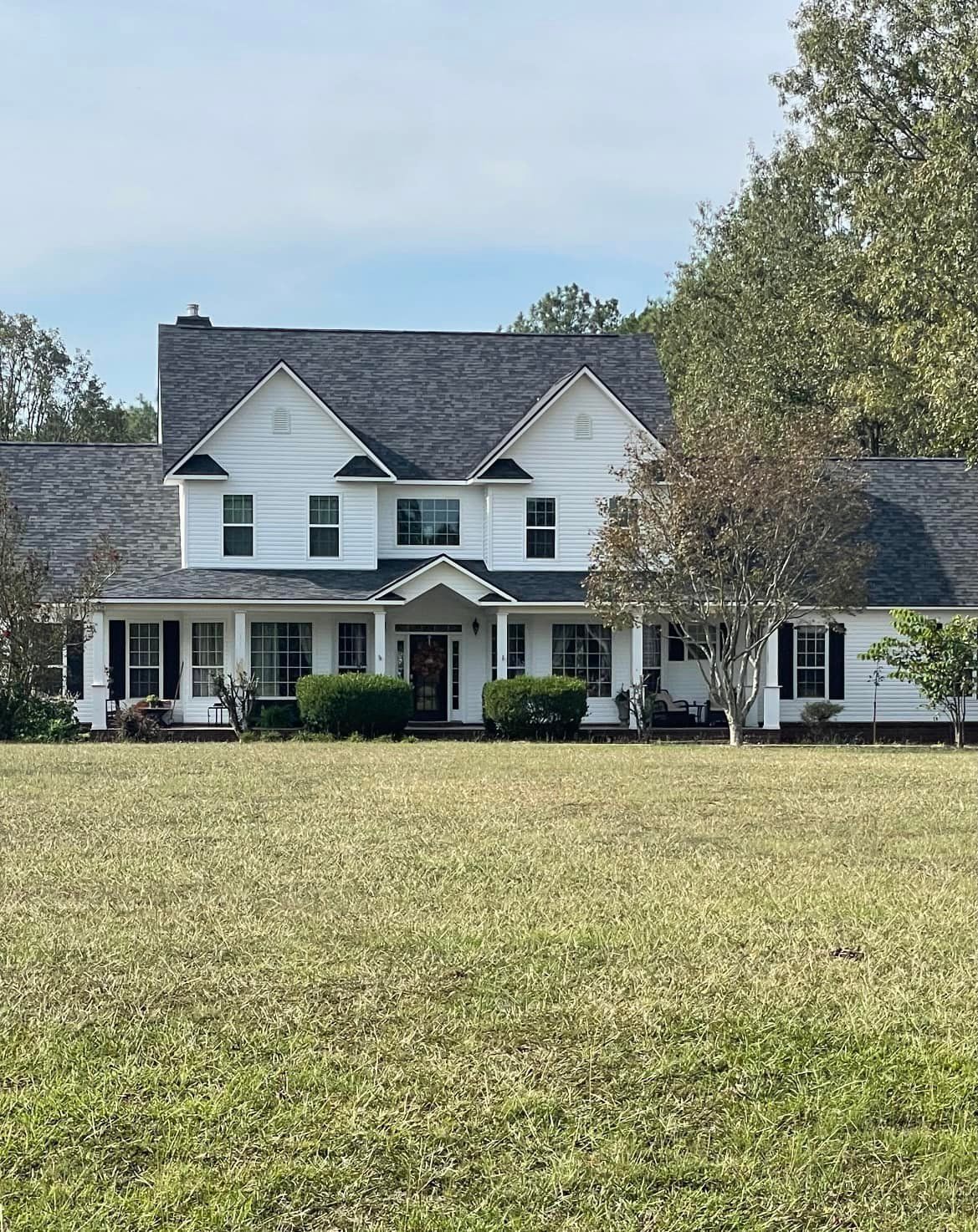 A large white house with a large lawn in front of it.