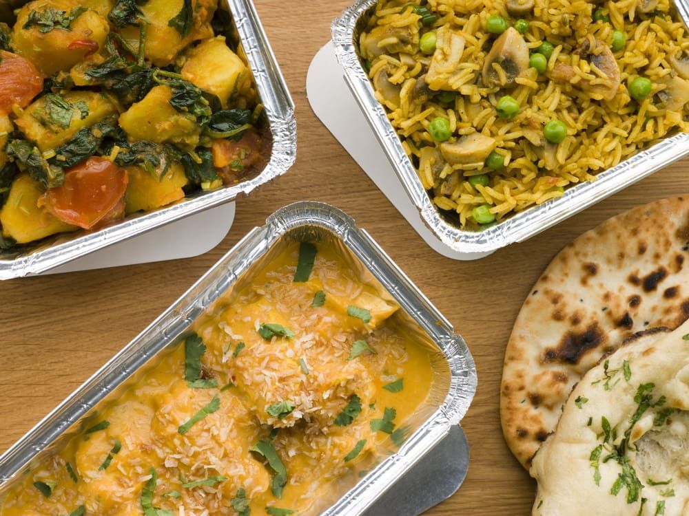 Three Containers Of Indian Food Are Sitting On A Table — Punjabi Sunrise Restaurant In Alexandra Hills, QLD