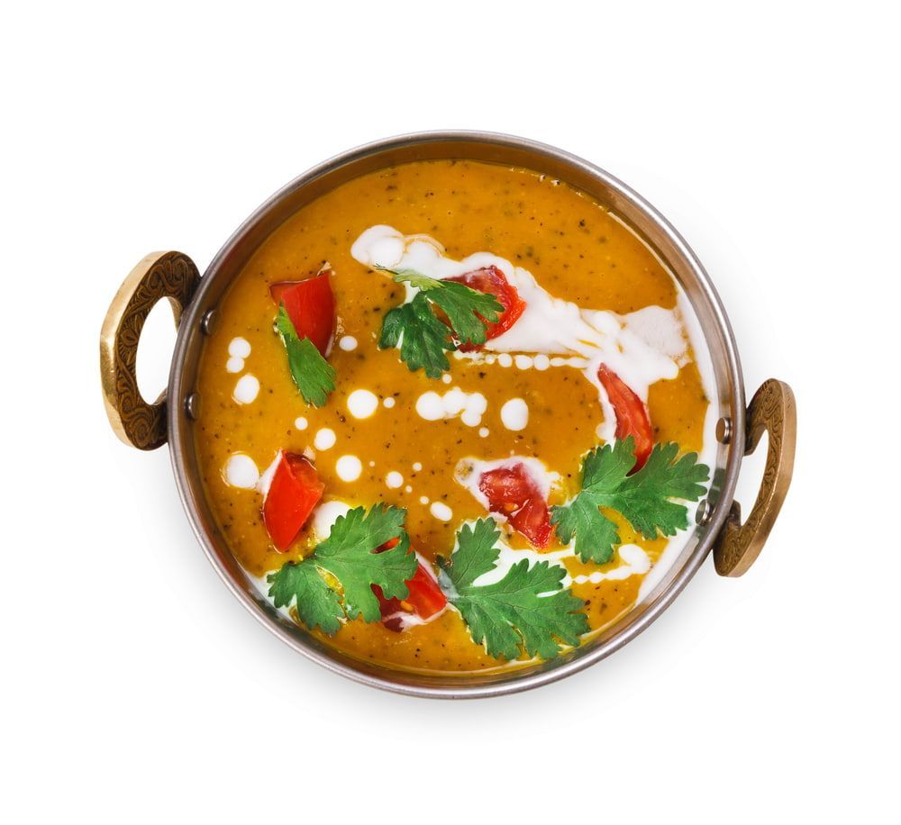 A Bowl of Soup With Tomatoes and Cilantro on a White Background — Punjabi Sunrise Restaurant In Alexandra Hills, QLD