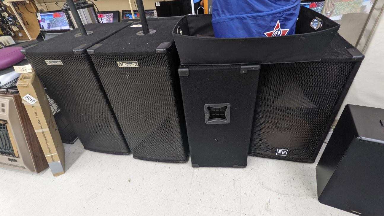 Several black speakers in a row; some tall, some square.