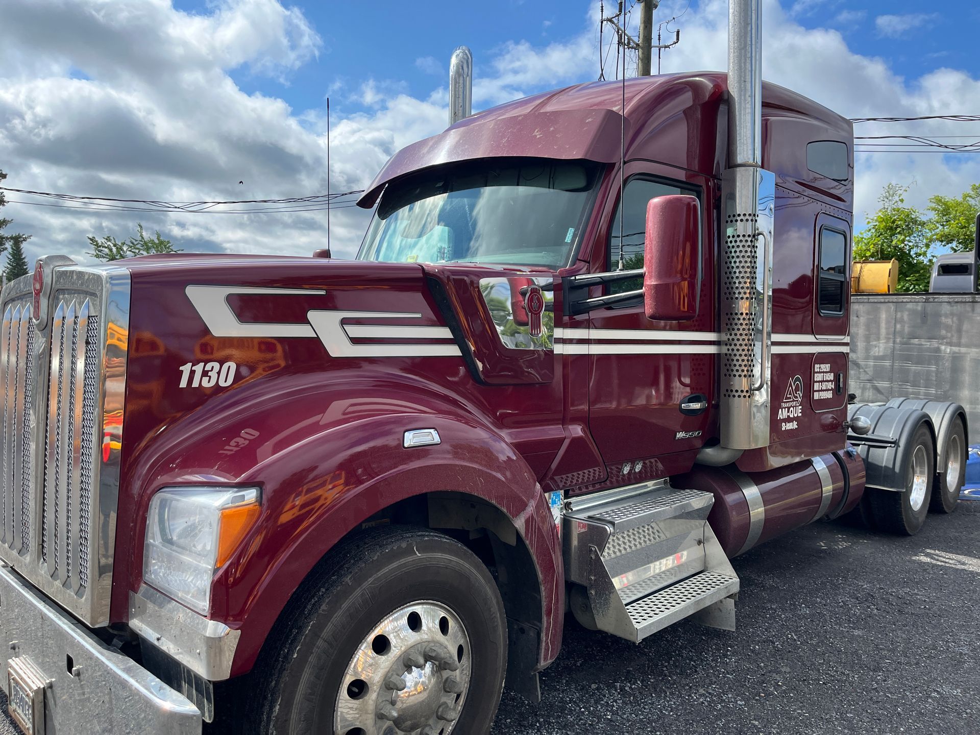 Semi-camion marron avec des accents chromés, stationné par temps nuageux.
