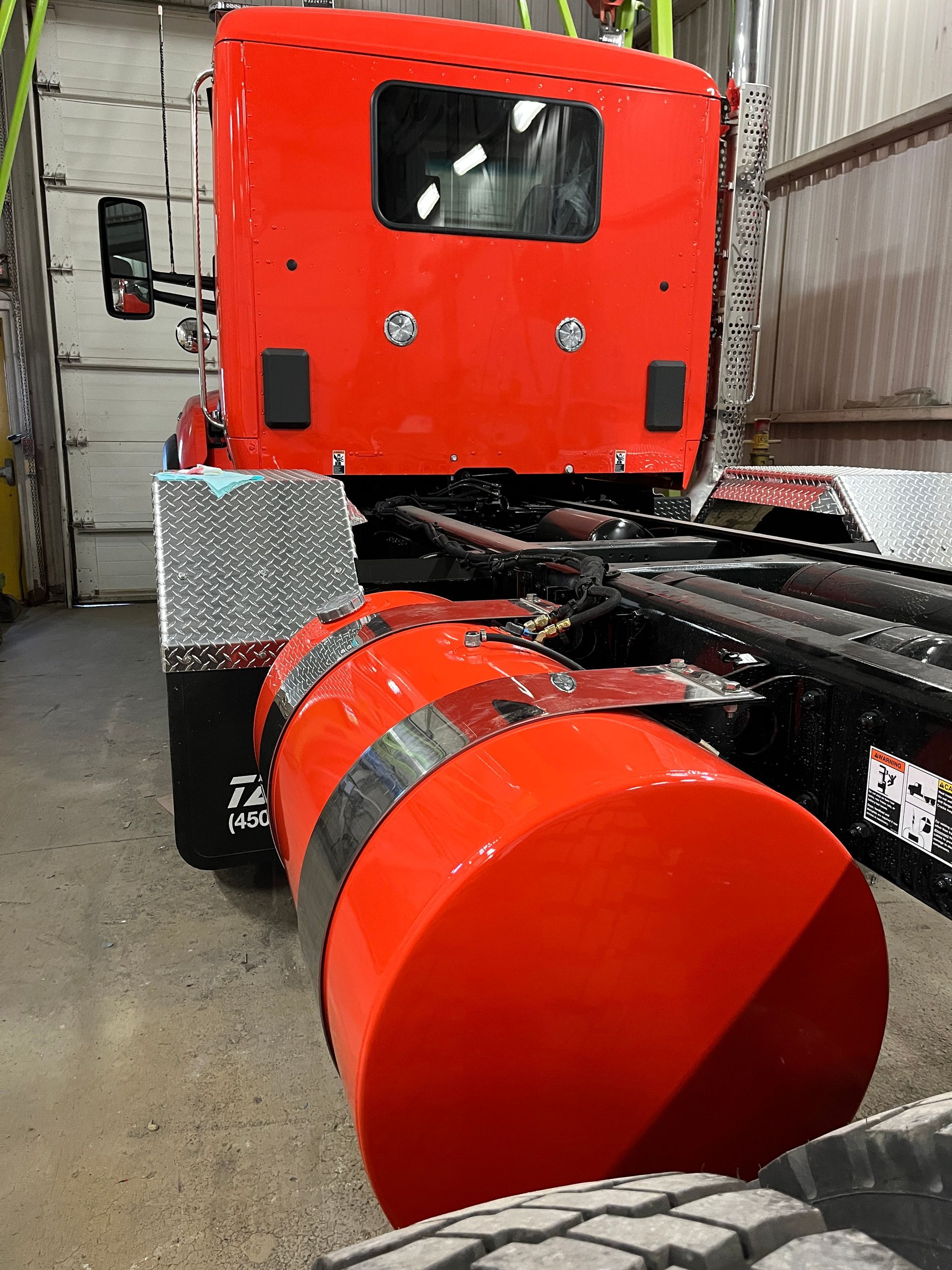 Réservoir de carburant de semi-remorque rouge et cabine arrière avec fenêtre dans un garage.