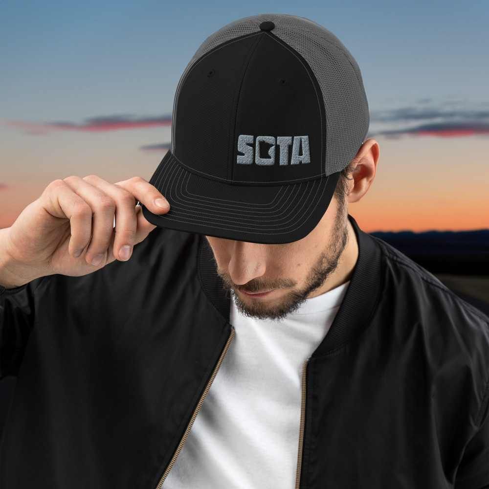 A man wearing a hat that says sota on it