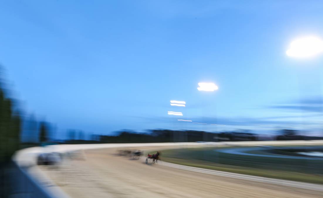 A horse completes a lap just after sunset