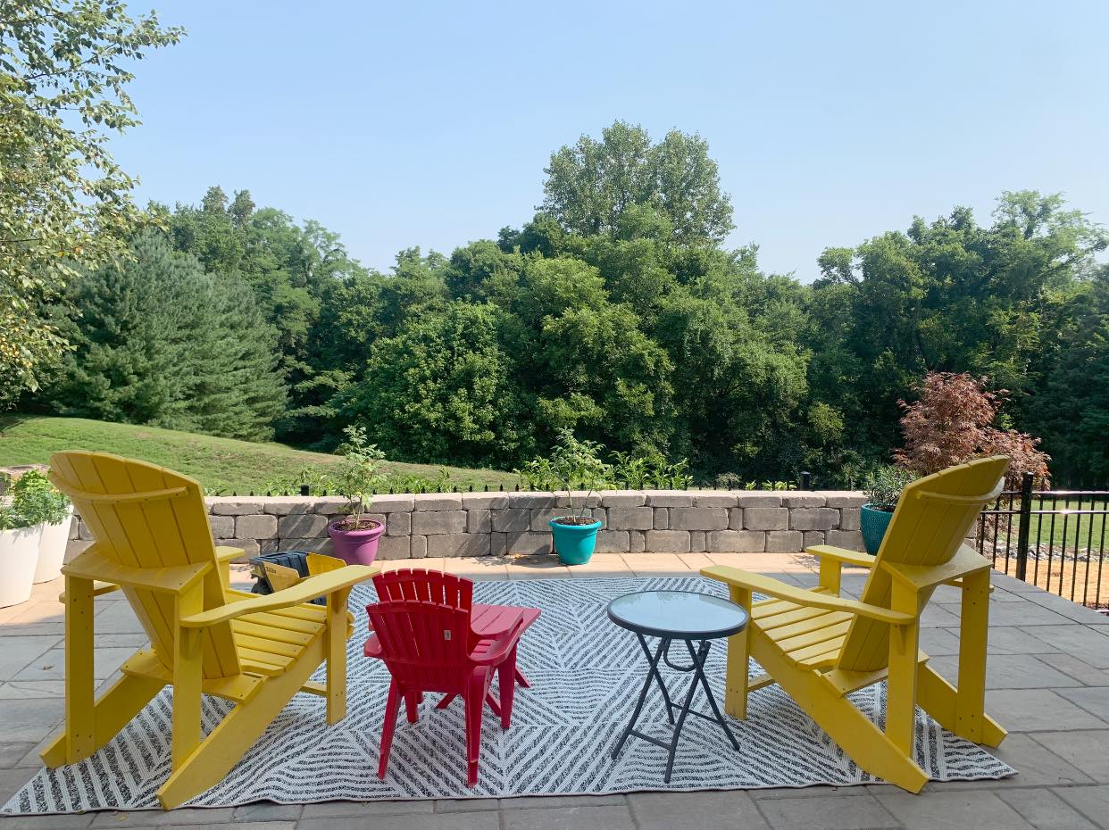 There are two yellow chairs and two red chairs on the patio.